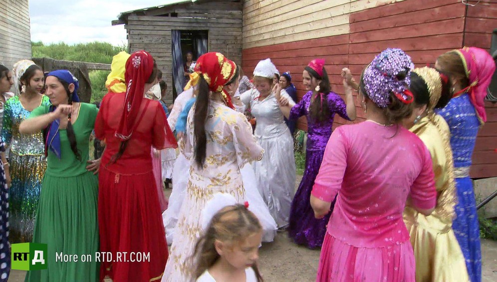 Group of Kalderash Gypsy women wearing long, colorful skirts, dance together at wedding